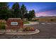 Inviting community entrance with brick signage and colorful flower beds at 7158 Torrey St, Arvada, CO 80007