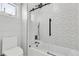 Well-lit bathroom with a sleek shower and modern patterned tiles at 6424 S Routt St, Littleton, CO 80127