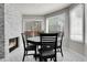 Bright dining room with a stone fireplace, modern table and chairs, and a sliding glass door at 6424 S Routt St, Littleton, CO 80127