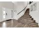 Bright foyer featuring a white door with sidelight and grand wood-look staircase at 6424 S Routt St, Littleton, CO 80127