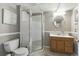 Clean bathroom featuring a glass-enclosed shower, vanity with wooden cabinets, and tile flooring at 4644 W 112Th Ct, Westminster, CO 80031