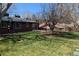 Well-maintained backyard with healthy lawn, brick house, and a covered patio area for outdoor enjoyment at 3400 Moore St, Wheat Ridge, CO 80033