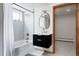 Bright bathroom featuring modern fixtures, including black vanity, marble countertop, and a tiled shower and tub at 3400 Moore St, Wheat Ridge, CO 80033