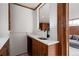 Stylish bathroom vanity with modern sink, quartz countertop, wood cabinetry, and a mirrored backsplash at 3400 Moore St, Wheat Ridge, CO 80033