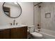 Stylish bathroom features a white marble countertop, wooden vanity and a shower-tub combination at 3400 Moore St, Wheat Ridge, CO 80033