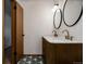 Bathroom featuring a dual sink vanity with marble countertop and patterned tile flooring at 3400 Moore St, Wheat Ridge, CO 80033