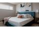 Stylish bedroom featuring a plush blue bed frame, white linens, and a decorative painting at 3400 Moore St, Wheat Ridge, CO 80033