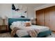 Bedroom featuring a plush blue bed, soft lighting, and modern art for a serene retreat at 3400 Moore St, Wheat Ridge, CO 80033