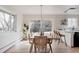 Sunlit dining area with wood floors, a modern table, and a view of the outdoor living space at 3400 Moore St, Wheat Ridge, CO 80033