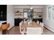 Bright dining room with wood table, stylish chairs, dark cabinets, and floating shelves creating an inviting space at 3400 Moore St, Wheat Ridge, CO 80033