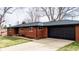 Front exterior of brick home with long driveway and an attached two-car garage at 3400 Moore St, Wheat Ridge, CO 80033