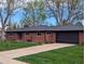 Charming red brick home with a well-manicured lawn and attached two car garage at 3400 Moore St, Wheat Ridge, CO 80033