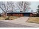 Charming brick ranch-style home featuring a well-maintained lawn and attached two-car garage at 3400 Moore St, Wheat Ridge, CO 80033