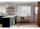 Modern kitchen featuring an island with seating, stainless steel sink, bright countertop and open shelving at 3400 Moore St, Wheat Ridge, CO 80033