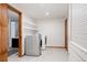 Bright laundry room with modern washer and dryer, shelving, and doorway leading to an adjacent bathroom at 3400 Moore St, Wheat Ridge, CO 80033