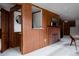 Living room featuring a brick fireplace and wood paneled walls at 3400 Moore St, Wheat Ridge, CO 80033