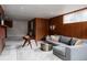 Cozy living room with wood paneling, gray sofa and patterned rug with fireplace at 3400 Moore St, Wheat Ridge, CO 80033