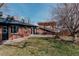 A covered patio area connects a brick house to a grassy backyard with a wood fence at 3400 Moore St, Wheat Ridge, CO 80033