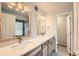Bright bathroom with a dual sink vanity, wooden framed mirrors, and a view to the backyard at 23678 Pondview Pl # D, Golden, CO 80401