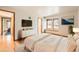 Staged bedroom featuring hardwood floors, lots of natural light, and clean white walls at 23678 Pondview Pl # D, Golden, CO 80401