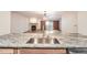 Modern kitchen with granite counters and stainless steel sink that opens to the living room at 23678 Pondview Pl # D, Golden, CO 80401