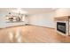 Unfurnished living room features hardwood floors, fireplace, and access to modern kitchen at 23678 Pondview Pl # D, Golden, CO 80401