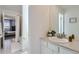 Bright bathroom featuring a vanity with a white countertop, mirror and view into the bedroom at 16308 Saint Paul St, Thornton, CO 80602