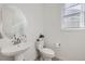 Stylish half-bathroom with a pedestal sink, modern fixtures, and a minimalist design at 16308 Saint Paul St, Thornton, CO 80602