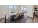 Elegant dining area with a modern table, seating for six, and a sliding door to the outdoor patio at 16308 Saint Paul St, Thornton, CO 80602