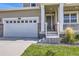 Close-up of the home's entrance with a two-car garage and well-kept landscaping at 16308 Saint Paul St, Thornton, CO 80602