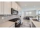 Modern kitchen featuring stainless steel appliances, white cabinets, and an adjacent dining area at 16308 Saint Paul St, Thornton, CO 80602