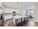 Open-concept kitchen featuring white cabinets, a large center island, and modern stainless steel appliances at 16308 Saint Paul St, Thornton, CO 80602
