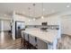 Bright kitchen with stainless steel appliances, quartz countertops, and stylish pendant lighting at 16308 Saint Paul St, Thornton, CO 80602