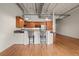 Kitchen with island with stools, stainless steel appliances, and hardwood floors at 1800 Lawrence St # 408, Denver, CO 80202