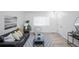 Light and airy living room with black leather sofa and entryway at 2030 Santana Dr, Castle Rock, CO 80104