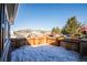 Small side yard with wooden fence and snow on the ground at 2030 Santana Dr, Castle Rock, CO 80104