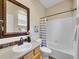 Traditional bathroom with a wooden vanity, framed mirror, and shower-tub combo at 1358 Carlyle Park Cir, Highlands Ranch, CO 80129