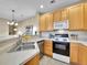 Bright kitchen featuring wood cabinets, modern appliances, and a stainless steel sink at 1358 Carlyle Park Cir, Highlands Ranch, CO 80129