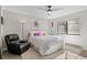 This bright bedroom has a ceiling fan, plush carpet, and a leather chair near a window at 534 E 7Th Ave # 206, Denver, CO 80203