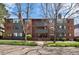 Exterior view of brick apartment building with mature trees and landscaping in front at 534 E 7Th Ave # 206, Denver, CO 80203