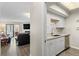 Cozy kitchen featuring white cabinets, marble countertops, and stainless steel appliances next to living room at 534 E 7Th Ave # 206, Denver, CO 80203