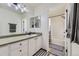 Bright bathroom featuring white cabinets, modern lighting, and a shower-tub combination at 9544 Longford Way, Parker, CO 80134