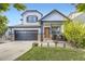 Inviting two-story home boasts a two-car garage, stone detailing, and a manicured lawn at 9544 Longford Way, Parker, CO 80134