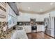 Bright kitchen featuring granite countertops, stainless steel appliances, and white cabinetry at 9544 Longford Way, Parker, CO 80134