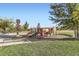 Community playground featuring multiple slides, climbing structures, and a bench with mature trees at 9544 Longford Way, Parker, CO 80134