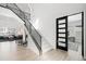 Elegant entryway with modern staircase and glass-paneled door at 6307 E 141St Ln, Thornton, CO 80602