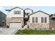 Two-story house with stone accents and a two-car garage at 6307 E 141St Ln, Thornton, CO 80602