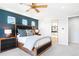 Main bedroom with dark blue accent wall and wood bed frame at 6307 E 141St Ln, Thornton, CO 80602