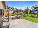 Spacious backyard with a pergola, fire pit, lush lawn, and mature trees at 2134 S Poppy St, Lakewood, CO 80228