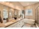 Modern bathroom featuring double vanity, soaking tub, and glass enclosed shower at 2134 S Poppy St, Lakewood, CO 80228